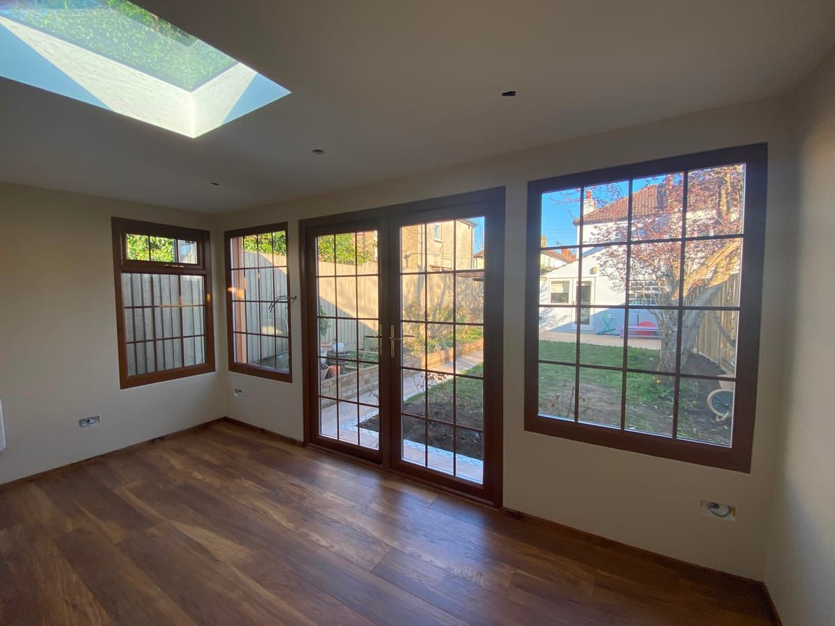 Newly finished garden room interior with hardwood French doors, a full-height picture window and a roof lantern
